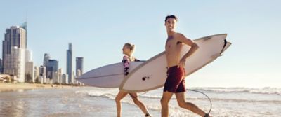Two surfers  on the beach with the Surfers Paradise skyline in the background